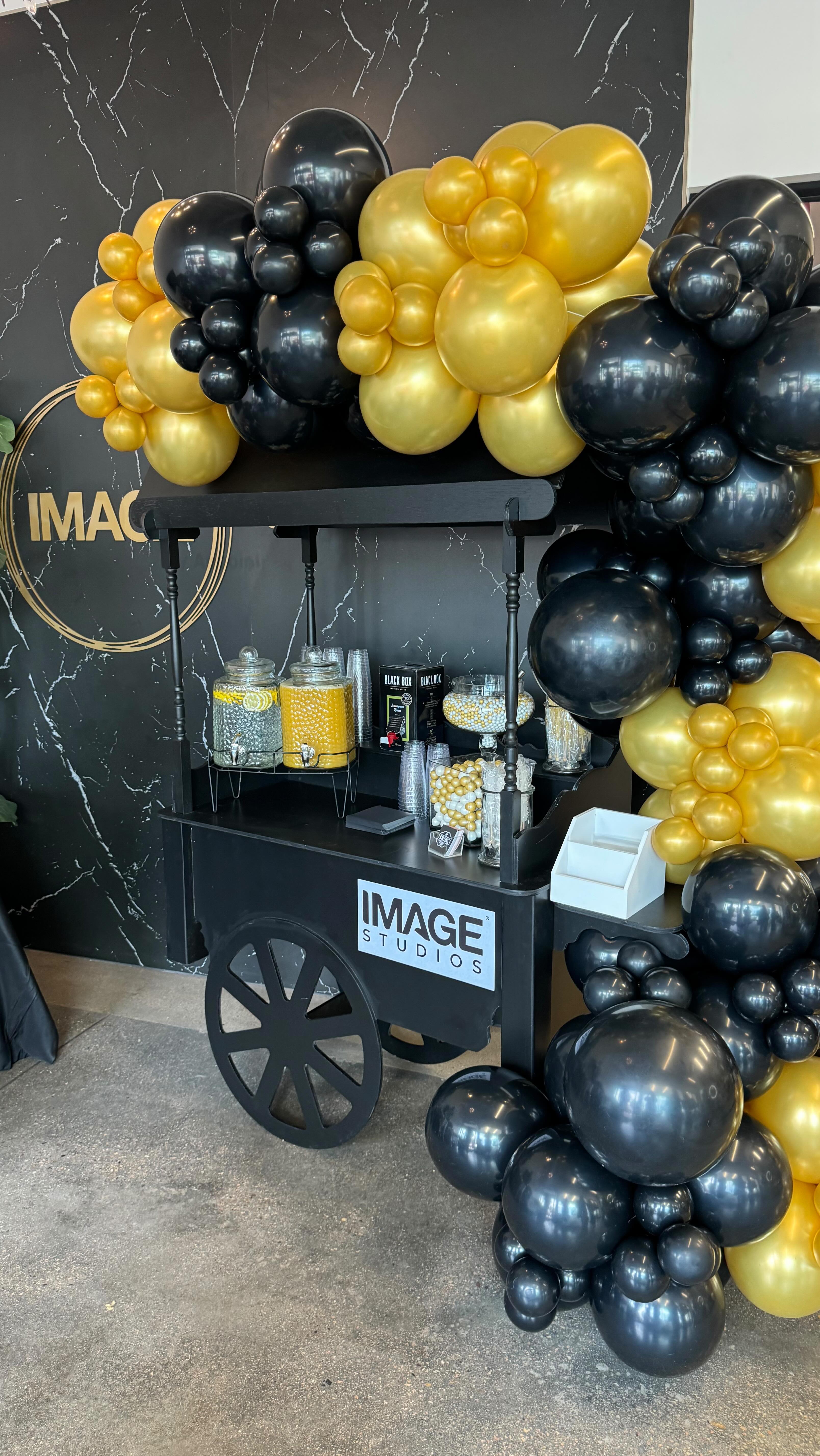Black cart with gold balloons at corporate event
